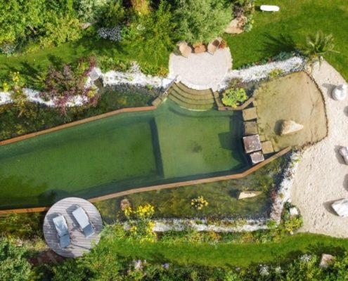 Luftbild: Hausgarten mit Schwimmteich und Strand